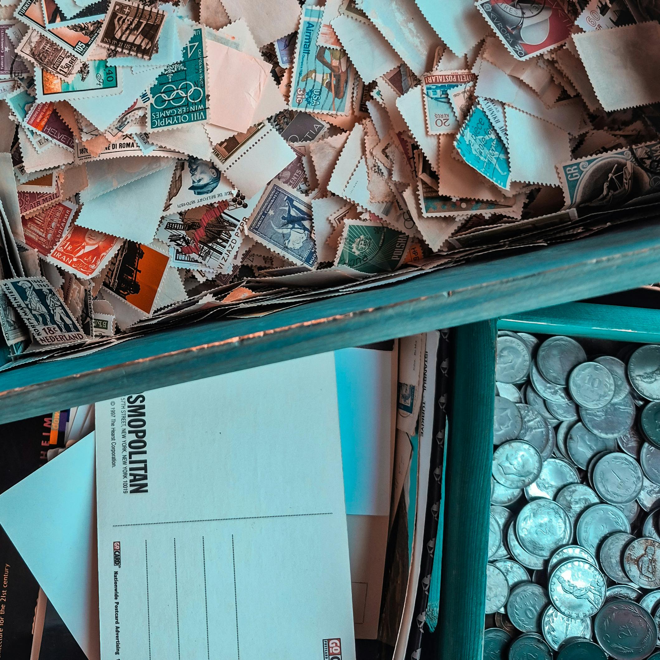 a photo of various collections, stamps, postcards and coins.